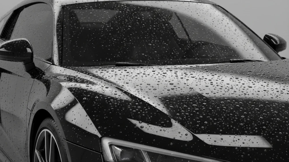 Auto met keramische coating wordt onderhouden met coating booster en microvezeldoek in de schaduw