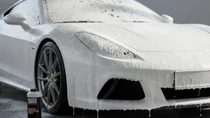 Koch Chemie Gentle Snow Foam fles naast een auto bedekt met dik wit schuim tijdens contactloze voorwas